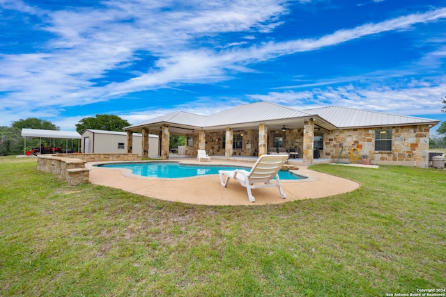 pool featuring a storage shed, an outdoor structure, a yard, a patio area, and a ceiling fan