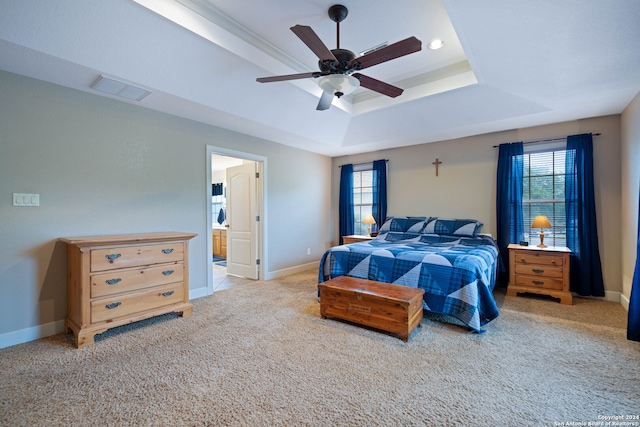 bedroom featuring visible vents, connected bathroom, baseboards, light carpet, and a raised ceiling