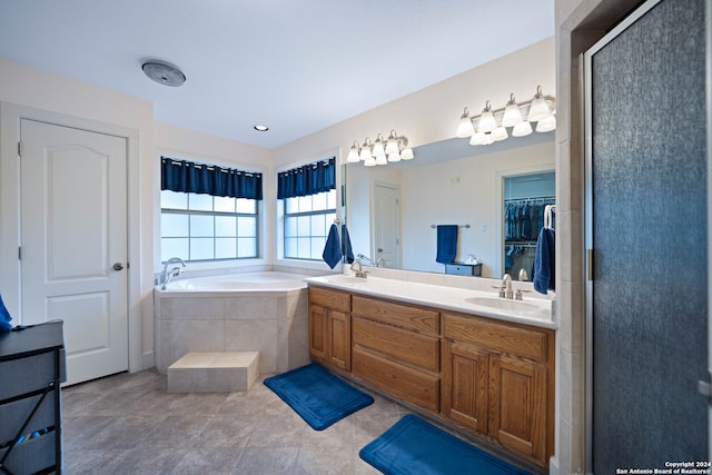 full bath with a sink, a stall shower, a bath, and double vanity