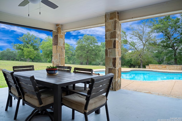 view of patio / terrace featuring an outdoor pool, outdoor dining area, and a ceiling fan