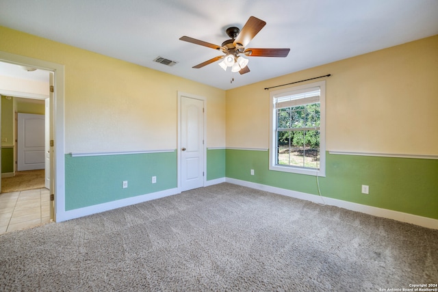 carpeted spare room featuring ceiling fan