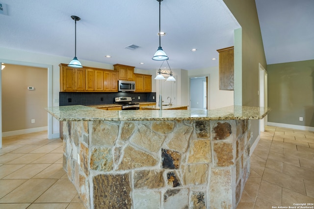 kitchen with stainless steel appliances, light tile patterned flooring, decorative backsplash, and hanging light fixtures