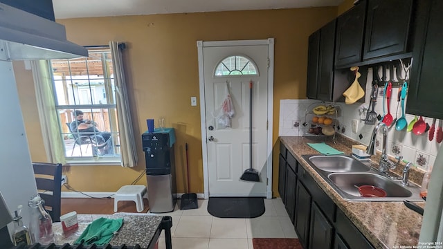 kitchen with tasteful backsplash, sink, and light tile floors