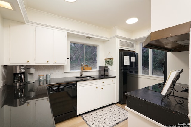 kitchen with sink, wall chimney range hood, white cabinetry, black appliances, and light hardwood / wood-style flooring