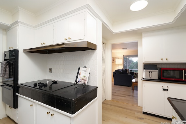 kitchen featuring light hardwood / wood-style floors, white cabinetry, and black appliances