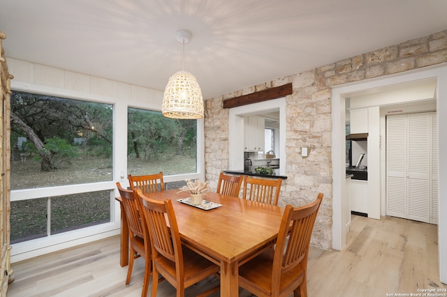 dining area with light hardwood / wood-style flooring and a notable chandelier