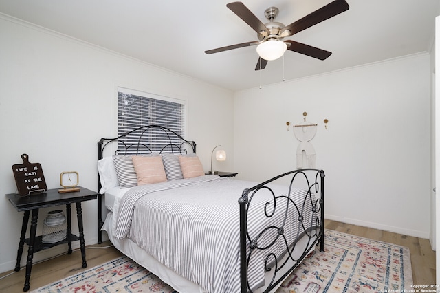 bedroom with hardwood / wood-style floors, ceiling fan, and ornamental molding