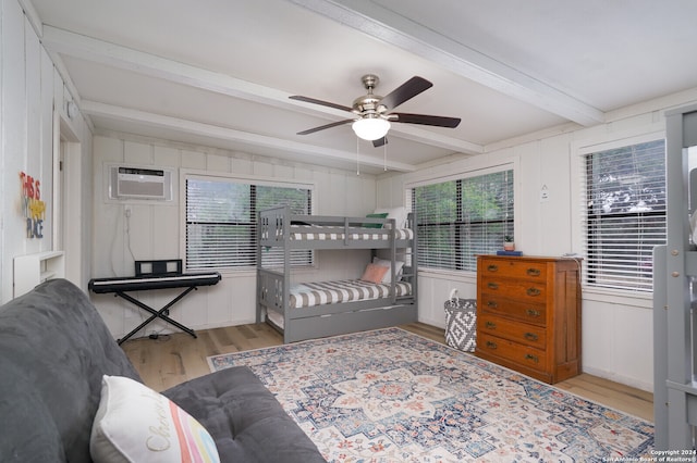 bedroom featuring light hardwood / wood-style flooring, beam ceiling, ceiling fan, and a wall unit AC