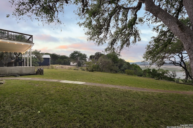 yard at dusk featuring a wooden deck