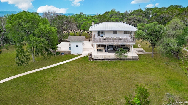 back of house featuring a deck and a yard