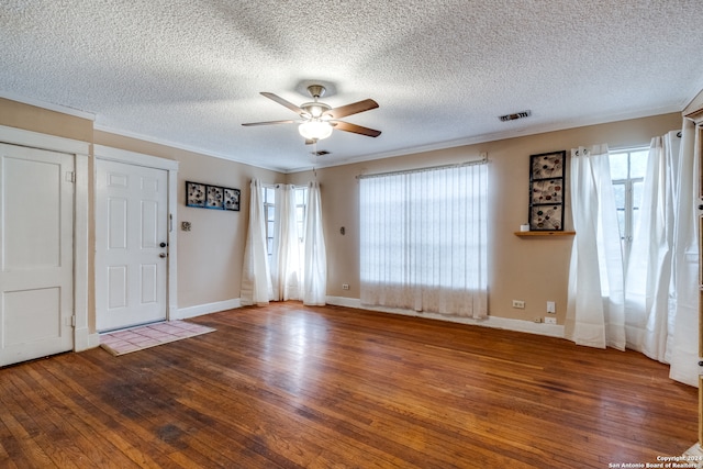 foyer entrance with a healthy amount of sunlight, dark hardwood / wood-style flooring, ceiling fan, and a textured ceiling