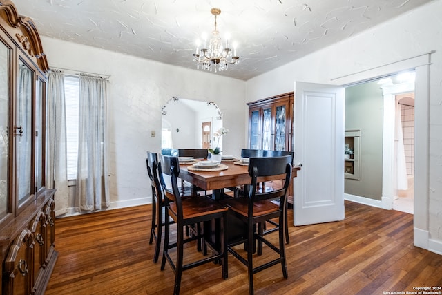 dining room with a healthy amount of sunlight, dark hardwood / wood-style flooring, and a notable chandelier