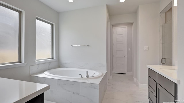 bathroom with vanity and separate shower and tub