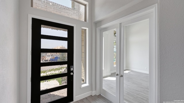 foyer featuring light hardwood / wood-style floors and french doors