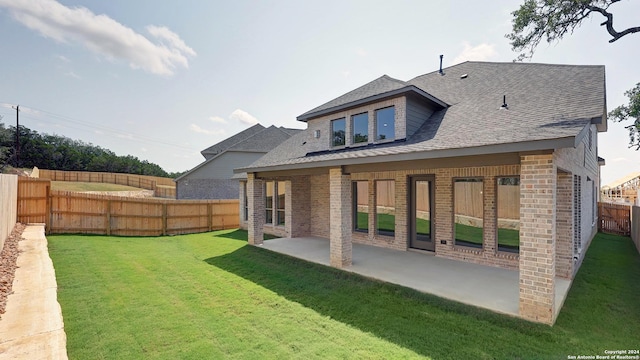 rear view of house featuring a lawn and a patio