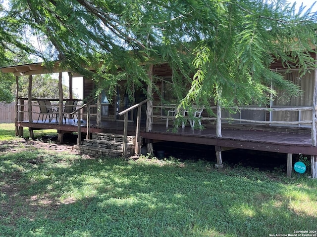 back of house featuring a wooden deck and a lawn