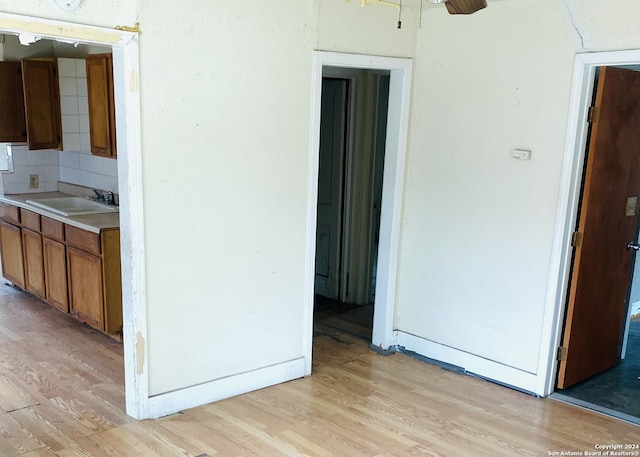 kitchen with backsplash, sink, and light wood-type flooring