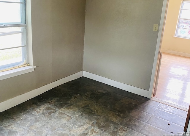 empty room with tile flooring and a healthy amount of sunlight