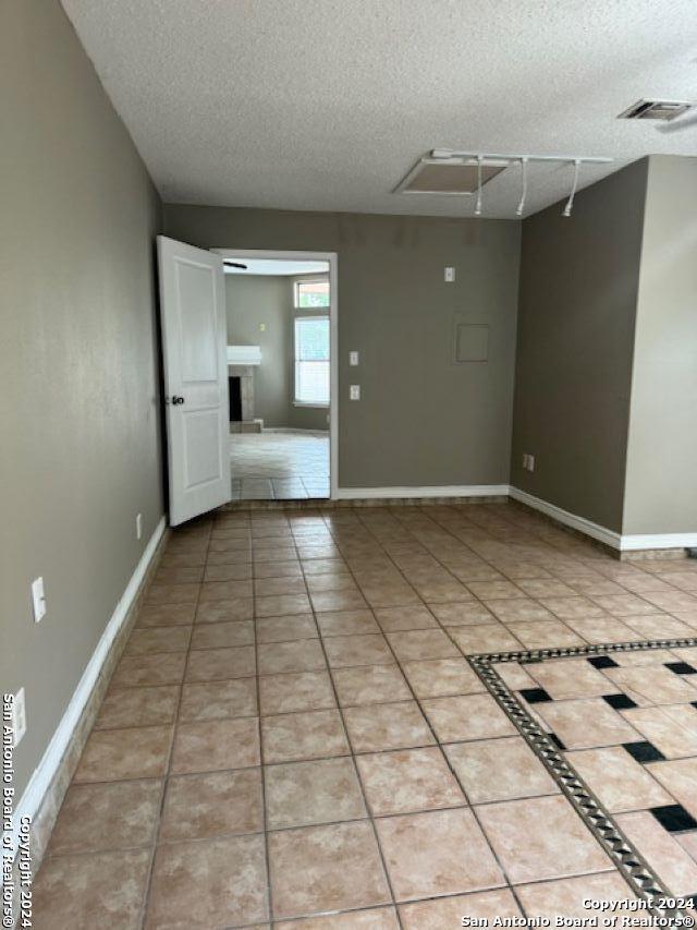 unfurnished room featuring tile floors and a textured ceiling