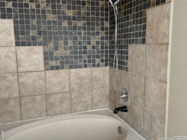 interior details featuring tiled shower / bath combo