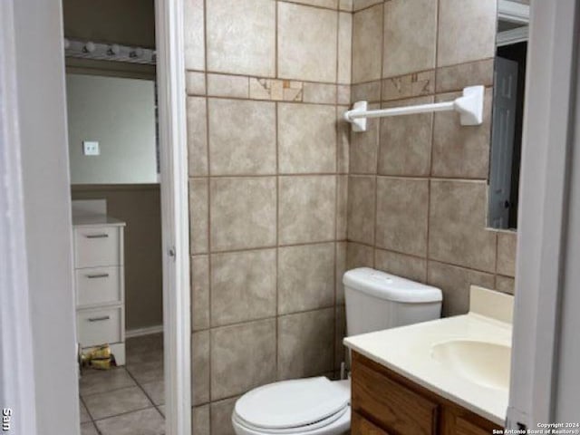 bathroom featuring toilet, oversized vanity, tile walls, and tile flooring