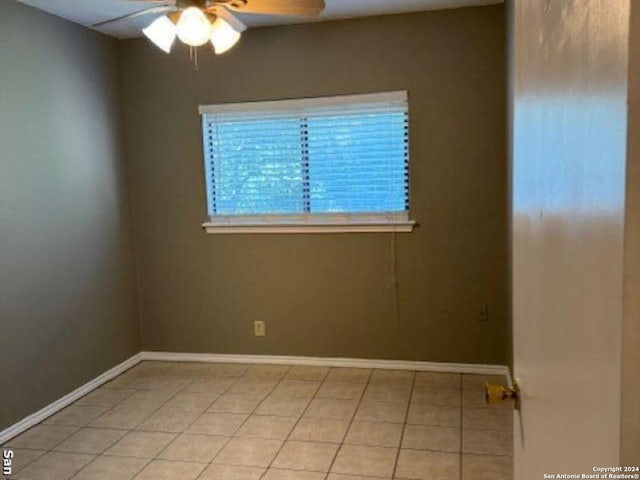 empty room featuring ceiling fan and light tile flooring