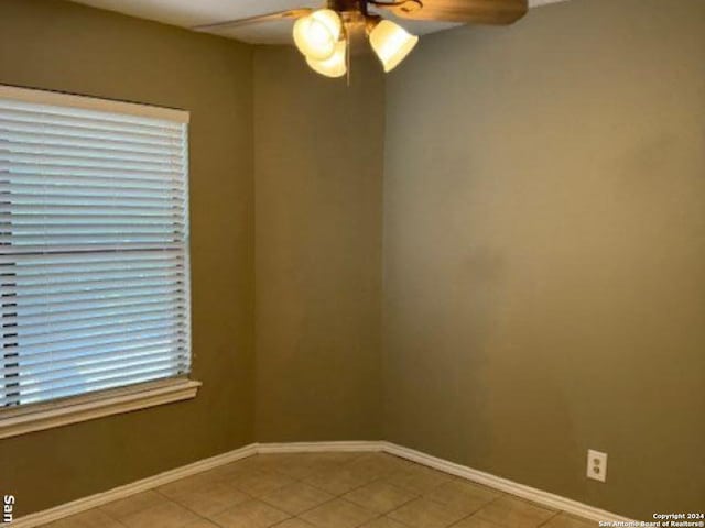 tiled spare room with ceiling fan