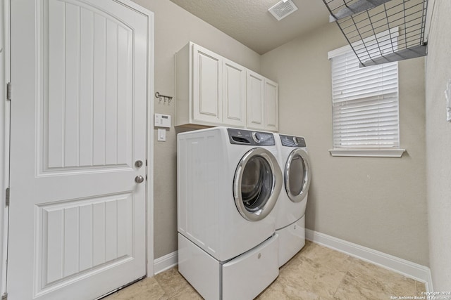 laundry area featuring cabinets, independent washer and dryer, and light tile floors