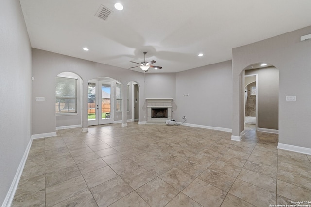 unfurnished living room with french doors, ceiling fan, and light tile floors