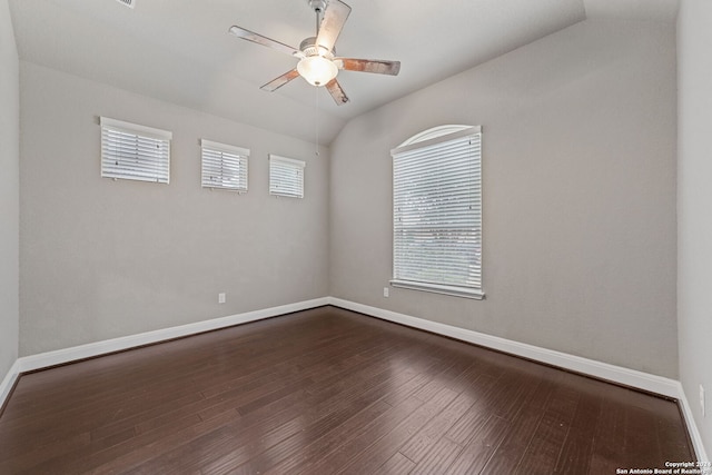 spare room featuring plenty of natural light, dark wood-type flooring, ceiling fan, and vaulted ceiling