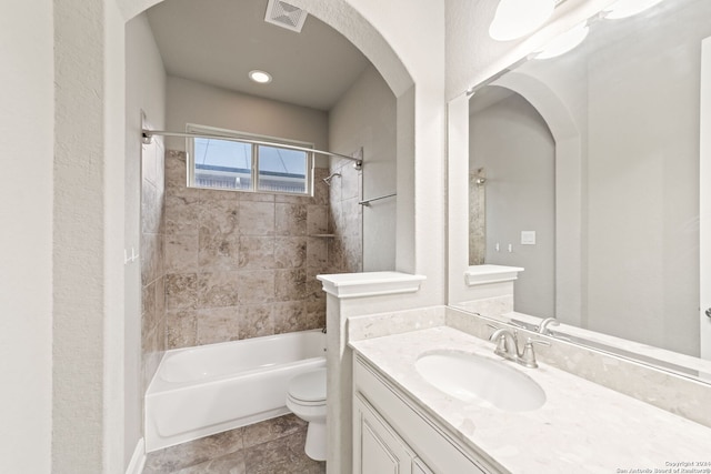 full bathroom with tiled shower / bath combo, toilet, tile flooring, and vanity