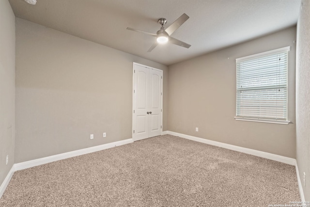 empty room with ceiling fan and carpet flooring