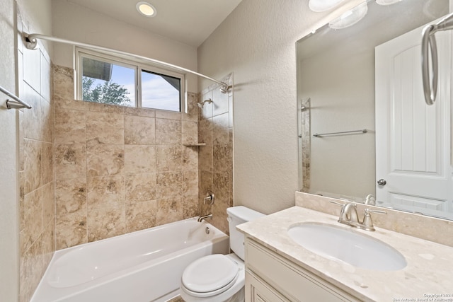 full bathroom with tiled shower / bath, toilet, and large vanity