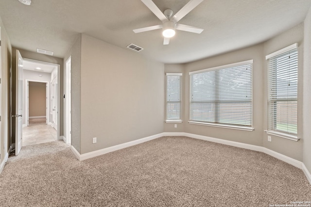 empty room with light colored carpet and ceiling fan