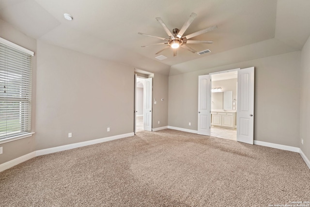 unfurnished bedroom featuring light colored carpet, ceiling fan, and connected bathroom