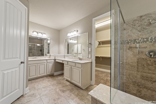 bathroom featuring tile flooring, walk in shower, and double sink vanity