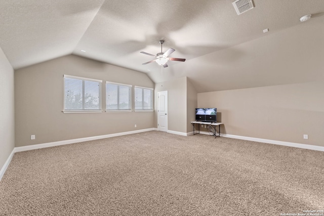 bonus room with a textured ceiling, vaulted ceiling, and carpet