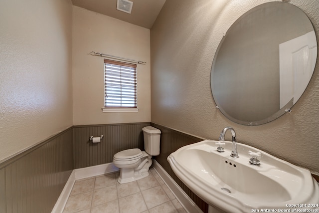 bathroom with toilet, tile flooring, and sink