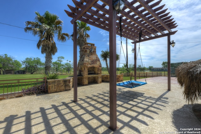 view of terrace with an outdoor stone fireplace and a pergola