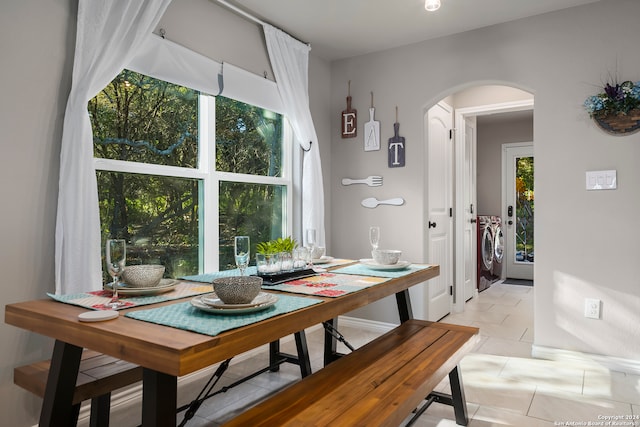 dining space with washer and clothes dryer and light tile patterned floors