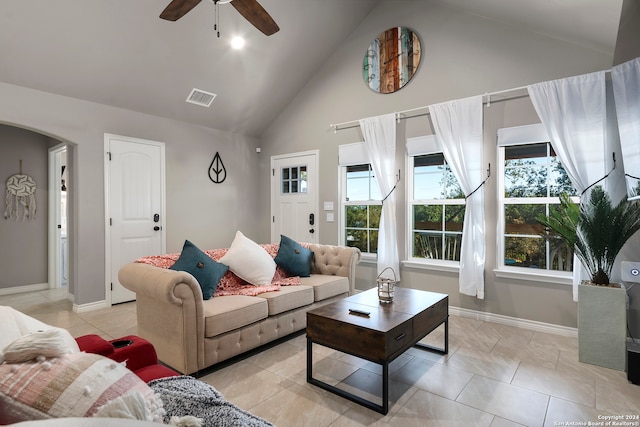 tiled living room with high vaulted ceiling, a wealth of natural light, and ceiling fan