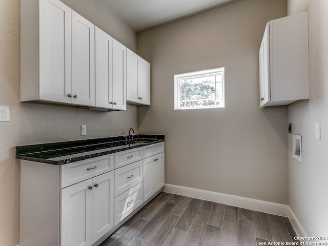 kitchen with dark stone countertops, dark wood-type flooring, and white cabinets