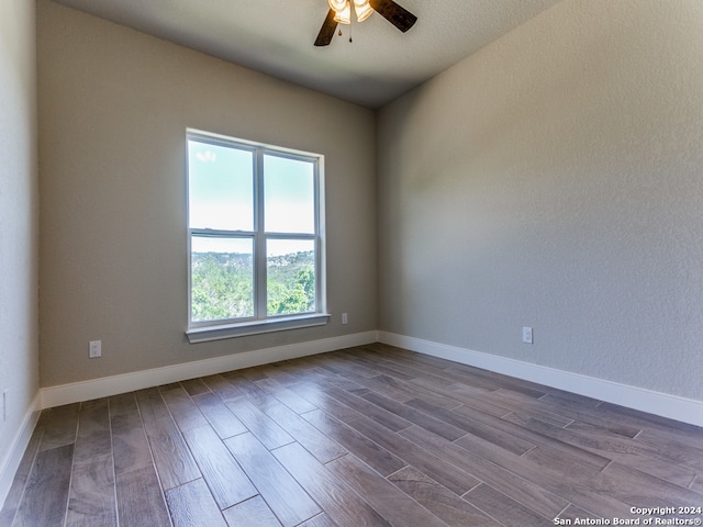 spare room featuring dark hardwood / wood-style flooring and ceiling fan