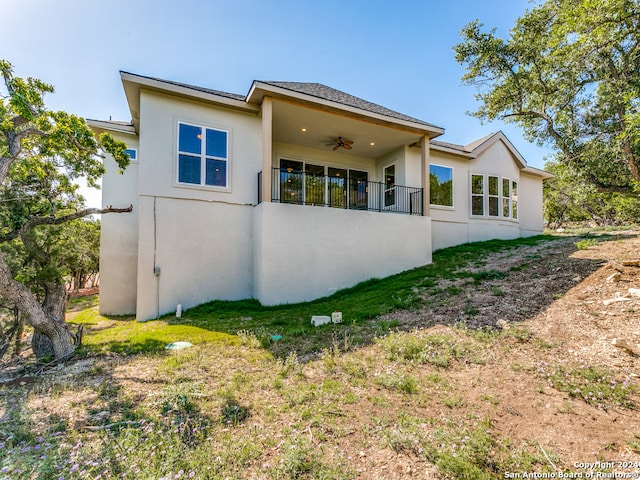 rear view of property featuring ceiling fan