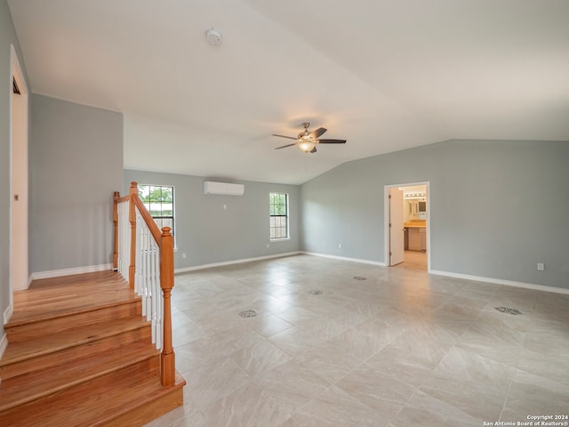 empty room featuring light hardwood / wood-style flooring, ceiling fan, an AC wall unit, and lofted ceiling