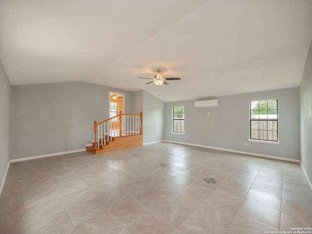 spare room featuring ceiling fan, light tile floors, and a wall unit AC