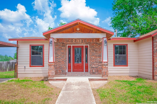 view of exterior entry with a lawn