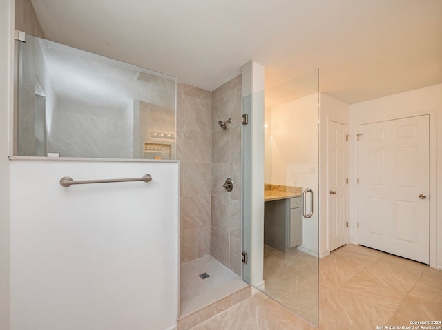 bathroom featuring tile flooring, vanity, and a tile shower