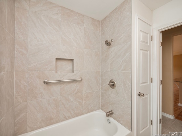 bathroom featuring tiled shower / bath and tile floors