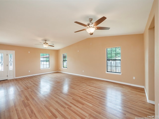 spare room with plenty of natural light, light hardwood / wood-style floors, ceiling fan, and vaulted ceiling